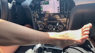 A sexy MILF gives a footjob and handjob while driving in POV style